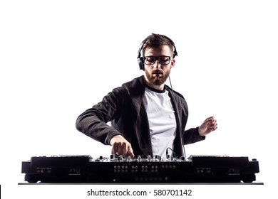Young stylish man in glasses posing behind mixing console on white studio background.