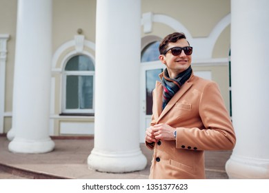 Young stylish man walking in city. Handsome guy wearing classic clothes and accessories. Street fashion. Man fastening buttons - Powered by Shutterstock