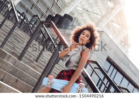 Similar – Young black woman, afro hairstyle, smiling near a wall in the street