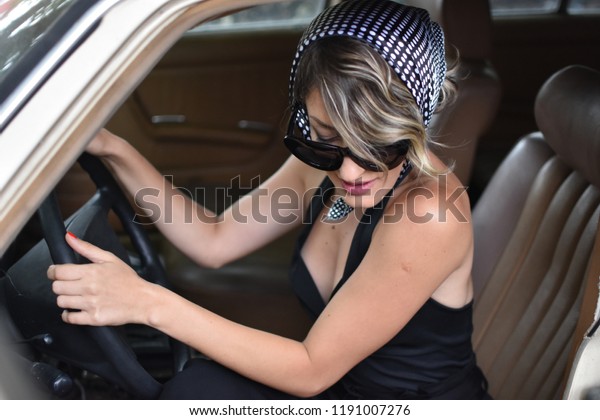 young stylish woman drive\
a retro car