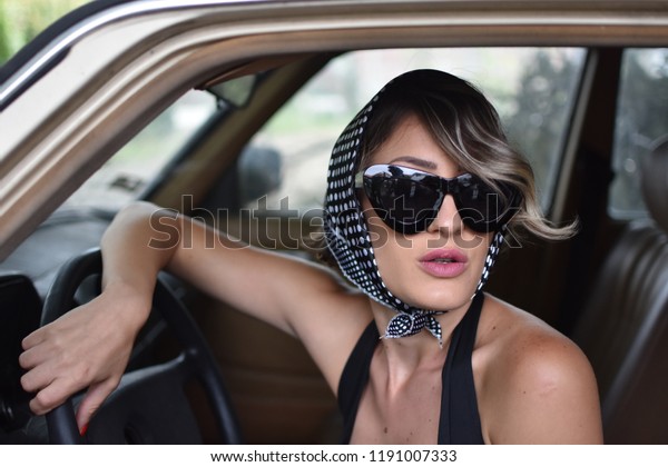 young stylish woman drive
a retro car