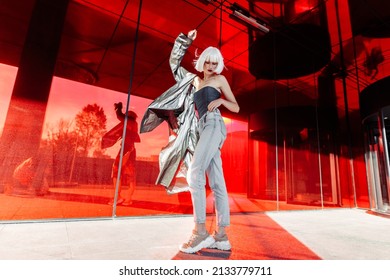Young stylish woman in a futuristic image on a red background. High quality photo