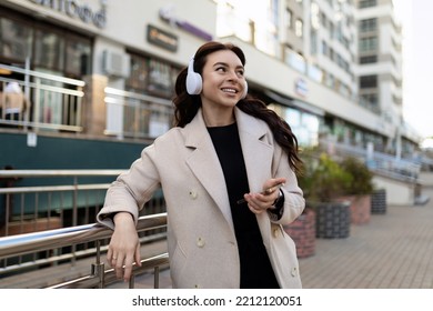 Young Stylish Woman Listening To Music On Headphones With A Big Smile On Her Face Outside The Office