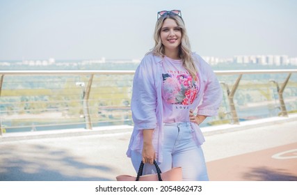 Young stylish woman walking on the city street. Casual fashion. Plus size model. Happy overweight woman walking the city streets