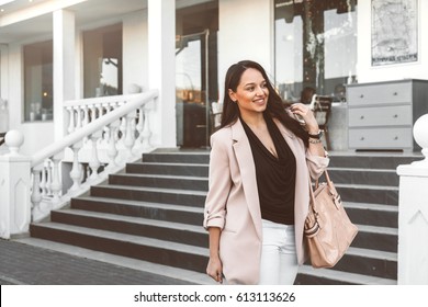 Young Stylish Woman Wearing Neutral Blazer With Handbag Walking On The City Street In Spring. Casual Fashion, Elegant Look. Plus Size Model.