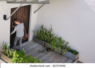 Young Successful Business Man Busy Locking His Front Door After Arriving At His Beach House