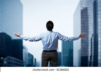 Young Successful Business Man Standing With Arms Wide Open In Front Of Buildings Business Center