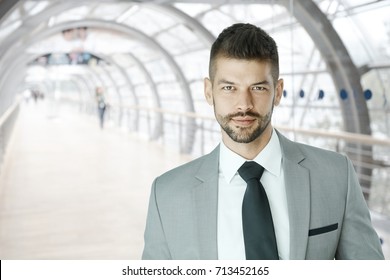 Young Successful Businessman In Fancy Suit Looking At Camera Inside Office Building.