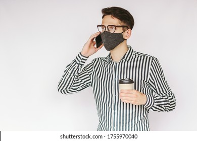 Young successful businessman in stylish protective face mask talk mobile phone and drink coffee isolated on white background. Happy male entrepreneur in medical face mask talk cell phone, coffee break - Powered by Shutterstock