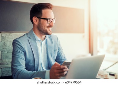 Young Successful Businessman Working On A Laptop While Sitting In Cafe.