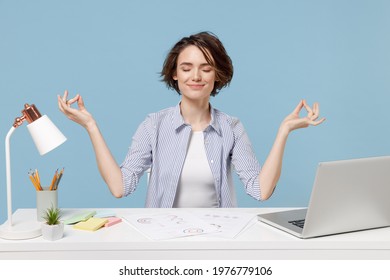 Young Successful Employee Business Woman In Casual Shirt Sit Work At White Office Desk With Pc Laptop Hold Hands In Yoga Om Gesture Relax Meditate Try To Calm Down Isolated On Blue Background Studio.