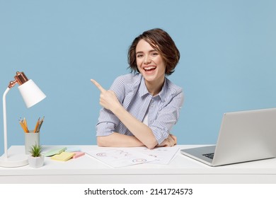 Young Successful Employee Business Woman 20s In Casual Shirt Sit Work At White Office Desk With Pc Laptop Point Index Finger Aside On Workspace Area Isolated On Pastel Blue Background Studio Portrait