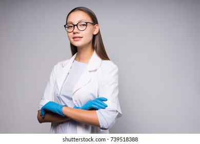 Young Successful Girl Doctor In Glasses And White Medical Dressing Gown Is Standing With Arms Folded On Chest