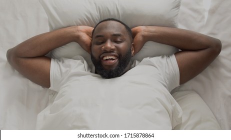 Young and successful man joyfully meeting new day morning in his bed, top view
 - Powered by Shutterstock