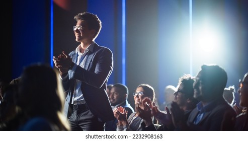 Young Successful Manager Rising Up and Jumping in Delight After a Very Strong and Emotional Speech by the Event Speaker. Handsome Specialist Celebrating and Cheering a Colleague on Stage. - Powered by Shutterstock