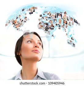 Young successful woman looking at worldmap with profile photos of her colleagues. International communication concept. - Powered by Shutterstock