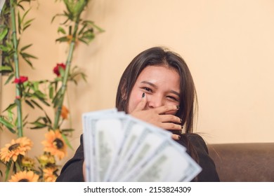 A Young Successful Woman Receiving Her First Salary. Feeling Shocked Yet Happy By The Unexpected Large Amount. Happy About Her Career And Job Performance.