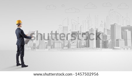 Young supervisor architect standing and replanning a big city panorama
