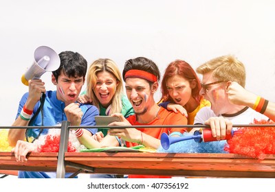 Young Supporters From Different Countries Watching Sport On Mobile Phone - Happy People Celebrating Football Match For Euro Cup - Friendship And Fraternity Concept - Main Focus On Guy In The Middle