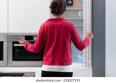 Young Suprised Woman And Her Empty  Fridge