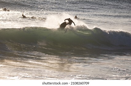 Young surfer doing trick on wave in Caños de Meca. Spanish Atlantic coast in Cadiz, perfect surfing spot in Europe