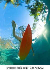 Young Surfer Paddling Through The Ocean