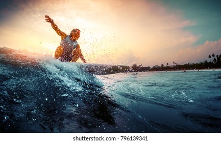 Junge Surfer reiten bei Sonnenuntergang