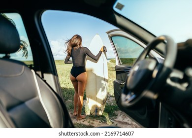 Young Surfer Woman In Her Car Getting Ready To Surf