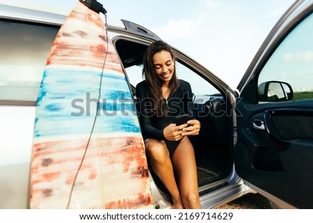 Young surfer woman in her car getting ready to surf