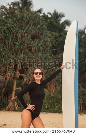 Similar – Surfer woman with bikini and wetsuit holding surfboard