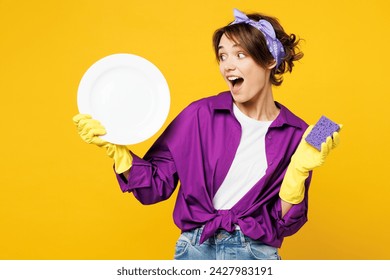 Young surprised amazed woman wear purple shirt rubber gloves casual clothes do housework tidy up wash dishes hold sponge, plate isolated on plain yellow background studio portrait Housekeeping concept - Powered by Shutterstock