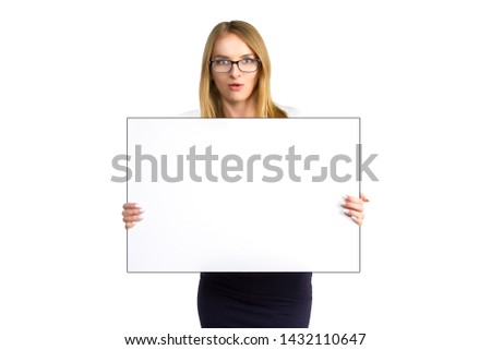 young surprised business woman in glasses is holding blank board isolated on white background. Attractive girl is showing white blank placard.