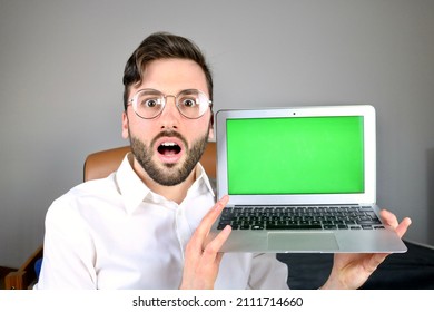 Young Surprised Computer Scientist Showing Laptop With Green Screen Display 