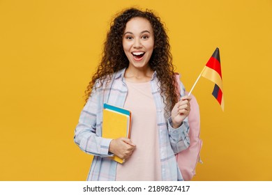 Young Surprised Excited Cool Black Teen Girl Student She Wearing Casual Clothes Backpack Bag Hold Books Germany Flag Isolated On Plain Yellow Color Background. High School University College Concept