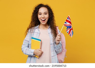 Young Surprised Excited Cool Black Teen Girl Student She Wearing Casual Clothes Backpack Bag Hold Books British Flag Isolated On Plain Yellow Color Background. High School University College Concept