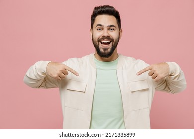 Young surprised exultant jubilant happy fun man 20s wearing trendy jacket shirt point index finger on himself isolated on plain pastel light pink background studio portrait. People lifestyle concept