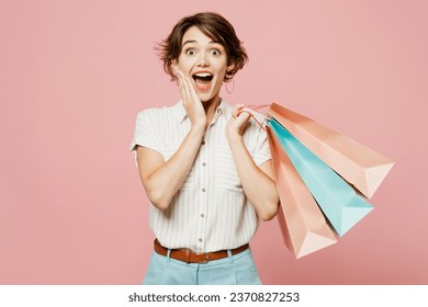 Young surprised happy woman wear casual clothes hold shopping paper package bags hold face look camera isolated on plain light pastel pink color background studio. Black Friday sale buy day concept - Powered by Shutterstock