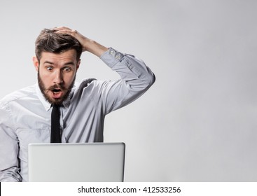 The young surprised man with his laptop computer - Shutterstock ID 412533256