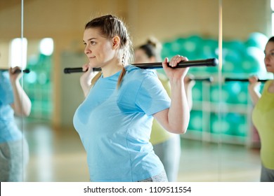 Young Sweaty Oversized Woman With Gymnastic Bar On Her Neck Training In Gym