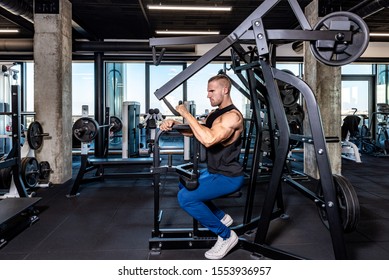 Young Sweaty Strong Muscular Fit Man Back Muscles Workout Training With Weights On The Machine In The Gym