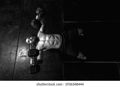 Young Sweaty Strong Muscular Fit Man With Big Muscles Doing Bench Press With Heavy Dumbbell Weights In The Gym As Hardcore Workout Training View From Above