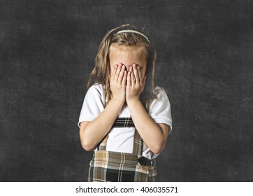 Young Sweet Junior Schoolgirl With Blonde Hair Crying Sad And Shy Standing Isolated In Front Of School Class Blackboard Wearing School Uniform In Children Education Stress And Bullying Victim