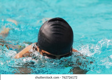 Young Swimmer With Black Swimming Cap Swims Breast Stroke In The Swimming Pool For Competition, Close Up