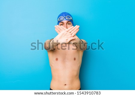 young guy with a tattoo on his back in colored shorts