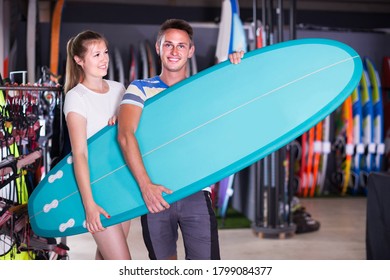 Young swiss couple is posing in surfboard store on the beach. - Shutterstock ID 1799084377