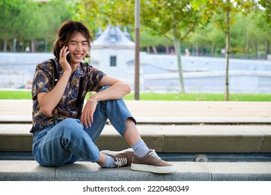 Young Taiwanese Man Smiling And Talking On The Smartphone At Street.