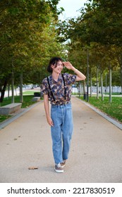 Young Taiwanese Man Smiling And Walking In A Park.