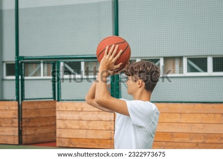 Similar – Image, Stock Photo Young talented basketball player is shooting hoops on his outdoor court and training for future games and tough situations. Preparing for the season. Shooting the basket