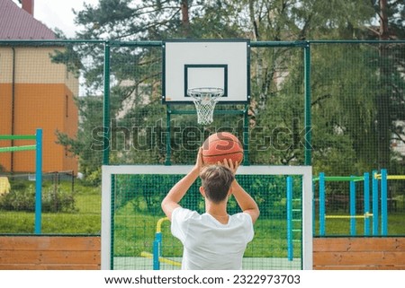 Similar – Image, Stock Photo Young talented basketball player is shooting hoops on his outdoor court and training for future games and tough situations. Preparing for the season. Shooting the basket