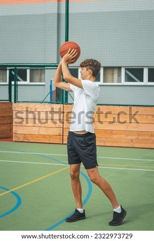 Similar – Image, Stock Photo Young talented basketball player is shooting hoops on his outdoor court and training for future games and tough situations. Preparing for the season. Shooting the basket